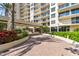 Beautiful condo building exterior featuring balconies, lush landscaping and elegant entryway at 1800 Benjamin Franklin Dr # B1009, Sarasota, FL 34236