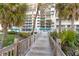 Inviting condominium complex with lush tropical landscaping and a charming boardwalk entrance at 1800 Benjamin Franklin Dr # B1009, Sarasota, FL 34236