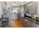 Modern kitchen with stainless steel appliances and black countertops, open to living area and ocean view at 1800 Benjamin Franklin Dr # B1009, Sarasota, FL 34236