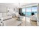 Bright living room with marble floors, modern white furniture, chandelier, and beautiful ocean views at 1800 Benjamin Franklin Dr # B1009, Sarasota, FL 34236