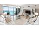 Bright living room with marble floors, modern white furniture, chandelier, and beautiful ocean views at 1800 Benjamin Franklin Dr # B1009, Sarasota, FL 34236