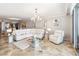 Bright living room features a modern chandelier, neutral decor, and marble flooring, with an open view to the dining area at 1800 Benjamin Franklin Dr # B1009, Sarasota, FL 34236