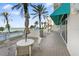Outdoor patio seating with ocean views, complemented by lush palm trees and a refreshing atmosphere at 1800 Benjamin Franklin Dr # B1009, Sarasota, FL 34236