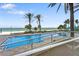 Stunning oceanfront pool surrounded by swaying palm trees and inviting lounge chairs for relaxation at 1800 Benjamin Franklin Dr # B1009, Sarasota, FL 34236