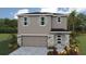 Charming two-story home featuring stone accents, a two-car garage, and a neatly landscaped front yard at 1906 Cobb Trl, Parrish, FL 34219