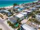 Beautiful aerial view of the beach home, neighborhood, and turquoise waters along the white sand beach at 2201 Avenue C, Bradenton Beach, FL 34217