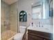 The bathroom is a blend of modern and organic style, features a glass shower and dark wood vanity at 2201 Avenue C, Bradenton Beach, FL 34217
