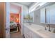 Bright bathroom with double vanity, white cabinets, and doorway to the bedroom at 2201 Avenue C, Bradenton Beach, FL 34217