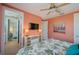 Cozy bedroom with coral walls, ceiling fan, floral bedding, and adjacent bathroom at 2201 Avenue C, Bradenton Beach, FL 34217
