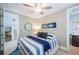 Serene bedroom with coastal accents, ceiling fan, ensuite bathroom, and adjacent staircase, blending comfort and style at 2201 Avenue C, Bradenton Beach, FL 34217