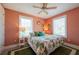 Tranquil bedroom featuring warm coral walls, floral bedding, and bright windows with ample sunlight at 2201 Avenue C, Bradenton Beach, FL 34217