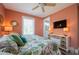 Inviting bedroom with bright walls, floral bedding, ceiling fan, TV, and access to ensuite bathroom at 2201 Avenue C, Bradenton Beach, FL 34217