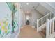 Inviting hallway leads to an upper level, featuring a tropical mural and clean white banister at 2201 Avenue C, Bradenton Beach, FL 34217