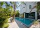 Backyard features a sparkling pool surrounded by lush tropical landscaping, offering a private oasis at 2201 Avenue C, Bradenton Beach, FL 34217