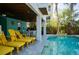Poolside patio features comfortable lounge chairs, an outdoor dining area, and lush tropical greenery at 2201 Avenue C, Bradenton Beach, FL 34217