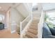 Elegant staircase with white railings leads to the upper level, complemented by neutral tones and natural light at 2201 Avenue C, Bradenton Beach, FL 34217
