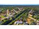 Overhead perspective of property outlined in yellow, adjacent houses, streets and waterways under a bright sky at 31 Twig Ct, Port Charlotte, FL 33954