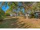 Expansive backyard featuring mature trees, lush greenery, and a metal barn, ideal for outdoor enjoyment at 31 Twig Ct, Port Charlotte, FL 33954
