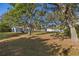 Beautiful backyard with mature trees and a metal barn, providing privacy and ample space for outdoor activities at 31 Twig Ct, Port Charlotte, FL 33954