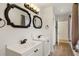 Bright bathroom featuring double sink vanity, decorative mirrors, and wood-look floors at 31 Twig Ct, Port Charlotte, FL 33954