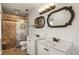 Bathroom featuring double sinks, modern fixtures, and a tiled shower with a glass door at 31 Twig Ct, Port Charlotte, FL 33954