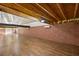 Spacious bonus room with exposed beam ceiling, brick wall, and wood flooring offers versatile living space at 31 Twig Ct, Port Charlotte, FL 33954