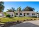 Charming single-story home featuring a well-maintained lawn, mature palm trees, and a welcoming facade at 31 Twig Ct, Port Charlotte, FL 33954