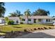 Charming single-story home featuring a well-maintained lawn, mature palm trees, and a welcoming facade at 31 Twig Ct, Port Charlotte, FL 33954