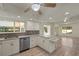 Bright kitchen featuring white cabinets, stainless steel appliances, and ample natural light from the adjacent dining area at 31 Twig Ct, Port Charlotte, FL 33954
