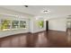 Inviting living room with dark hardwood floors, wainscoting, and natural light from large windows at 31 Twig Ct, Port Charlotte, FL 33954