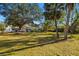 Spacious property featuring lush lawn and mature trees in a serene setting at 31 Twig Ct, Port Charlotte, FL 33954