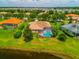 Aerial view of a home with screened-in pool and patio, lush green yard, and barrel tile roof at 312 148Th Ne Ct, Bradenton, FL 34212