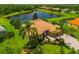 Aerial shot of house overlooking a lake with manicured lawn and landscaping and screened in pool at 312 148Th Ne Ct, Bradenton, FL 34212
