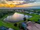 Sunset aerial view of a large lakefront property with a barrel tile roof, lush landscaping, and nearby homes at 312 148Th Ne Ct, Bradenton, FL 34212