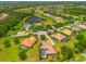 Aerial view of a residential area with multiple homes, lush greenery, and a serene pond at 312 148Th Ne Ct, Bradenton, FL 34212