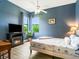 Cozy bedroom featuring blue walls, natural light, decorative fireplace, and hardwood floors at 312 148Th Ne Ct, Bradenton, FL 34212