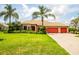 Inviting single-story home featuring lush landscaping, a tile roof, and a spacious three-car garage at 312 148Th Ne Ct, Bradenton, FL 34212