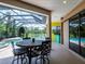 Covered patio and outdoor dining space overlooks the screened in pool, hot tub, and lake at 312 148Th Ne Ct, Bradenton, FL 34212