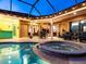 Luxurious covered pool area with a hot tub, bar seating, and spacious lounge area, creating a perfect outdoor oasis at 312 148Th Ne Ct, Bradenton, FL 34212