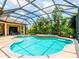 Backyard with screened in pool and hot tub, surrounded by lush landscaping and mature trees at 312 148Th Ne Ct, Bradenton, FL 34212