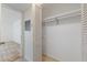 A closet with bifold doors and a single shelf, leading into an adjacent carpeted room at 3253 Beneva Rd # 103, Sarasota, FL 34232
