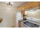 The kitchen features wood cabinetry, white appliances, a tile backsplash, and black countertops at 3253 Beneva Rd # 103, Sarasota, FL 34232