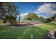 Enclosed tennis court, surrounded by lush greenery and a meticulously manicured lawn at 3253 Beneva Rd # 103, Sarasota, FL 34232