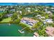 Expansive aerial shot of waterfront property with a private dock, lush greenery, and sparkling waters at 3799 Flamingo Ave, Sarasota, FL 34242