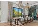 Dining room with large window, seating for six, wine storage, and modern chandeliers at 3799 Flamingo Ave, Sarasota, FL 34242