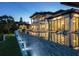 Modern home with infinity pool and lush landscaping, featuring outdoor lighting, covered balconies, and a spacious outdoor entertainment area at 3799 Flamingo Ave, Sarasota, FL 34242