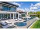 Beautiful backyard featuring a pool, spa, lounging area, and lush landscaping at 3799 Flamingo Ave, Sarasota, FL 34242