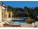 Backyard retreat with pool, fire pit, and covered seating area amidst lush tropical landscaping, perfect for relaxation and entertainment at 3799 Flamingo Ave, Sarasota, FL 34242