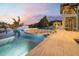 Custom infinity pool with a fire pit and lounge seating overlooking the waterway at dusk at 3799 Flamingo Ave, Sarasota, FL 34242