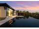 Stunning infinity pool overlooking lush greenery with a poolside lounge and an outdoor bar at 3799 Flamingo Ave, Sarasota, FL 34242